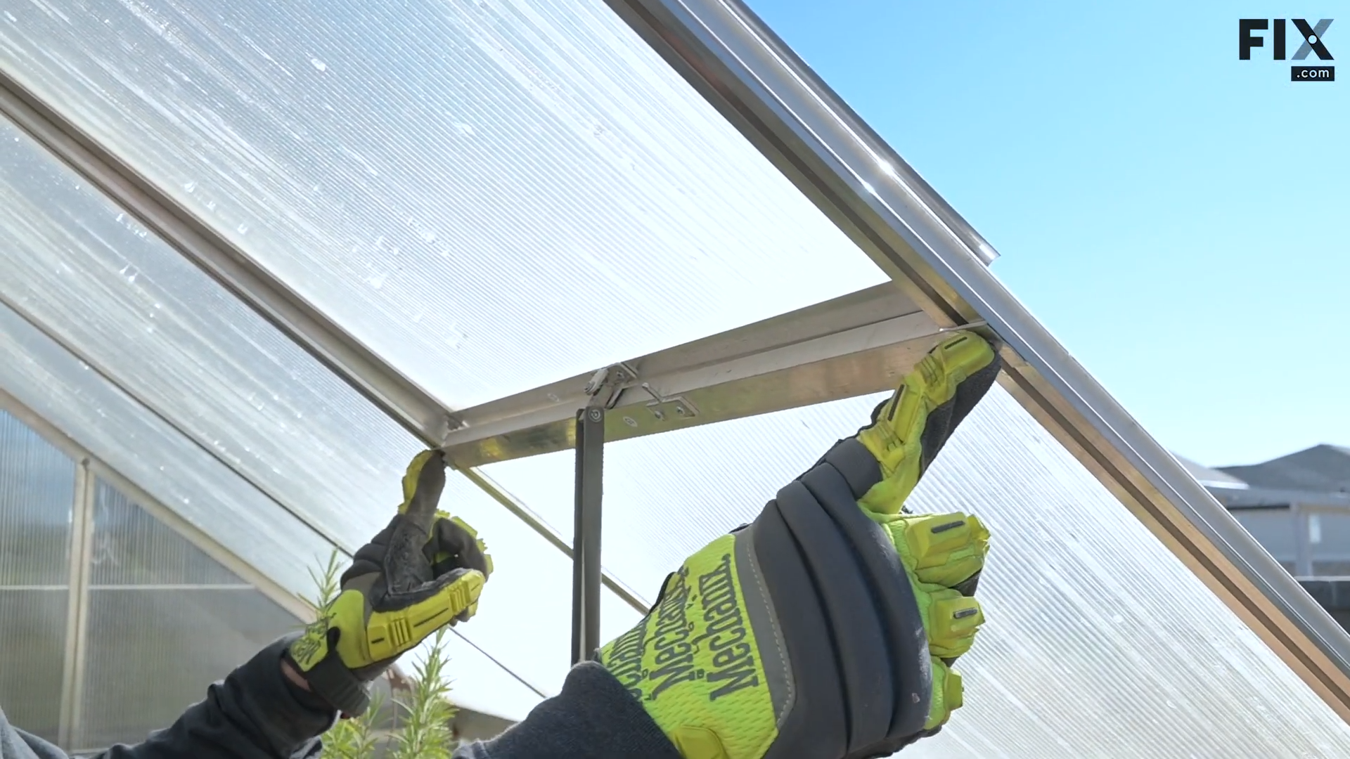 Expert technician locating the nuts found on the partition of a greenhouse vent and pointing the nuts out