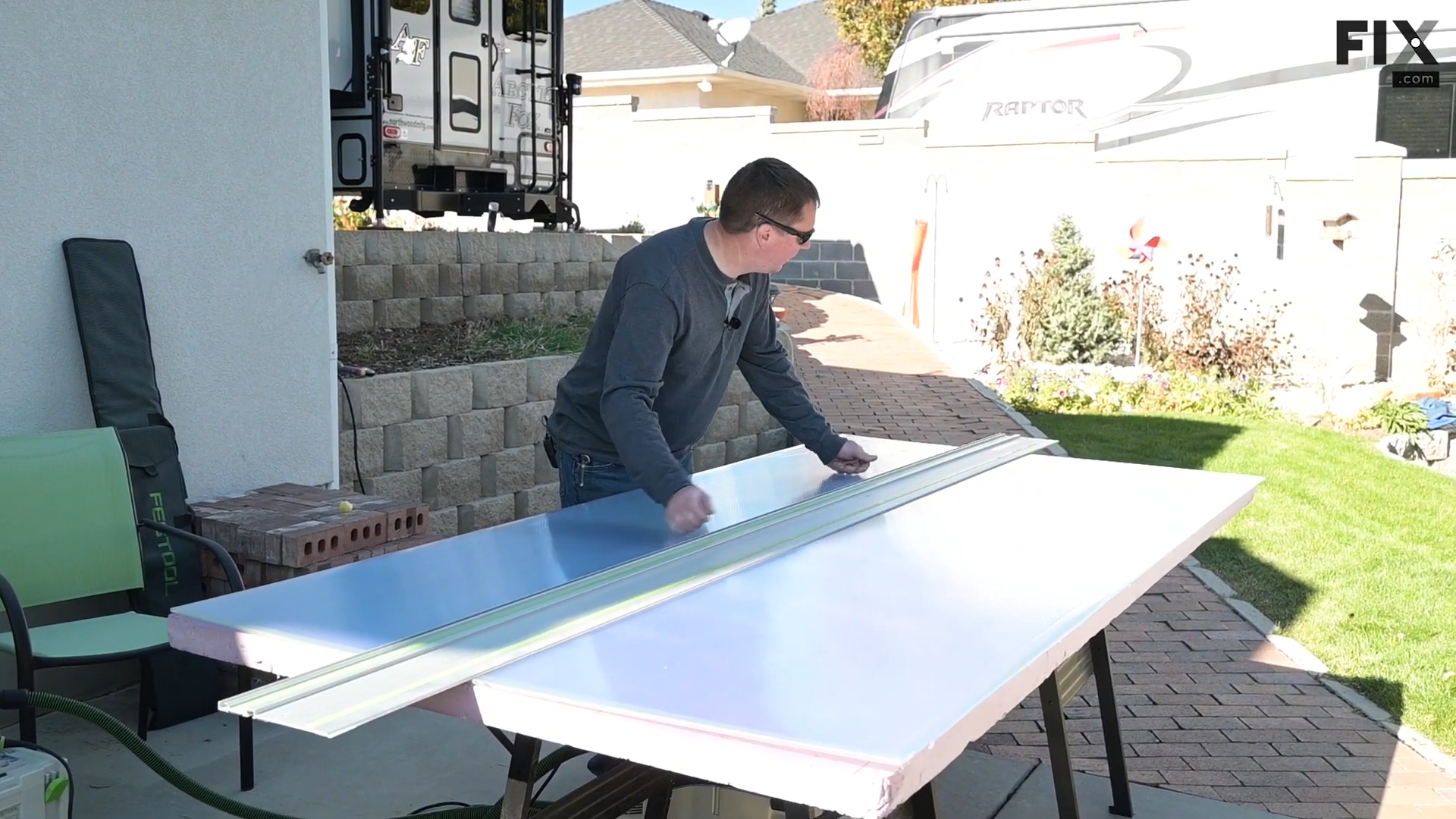 Expert technician laying down the track for a track saw on top of a sheet of double-wall polycarbonate