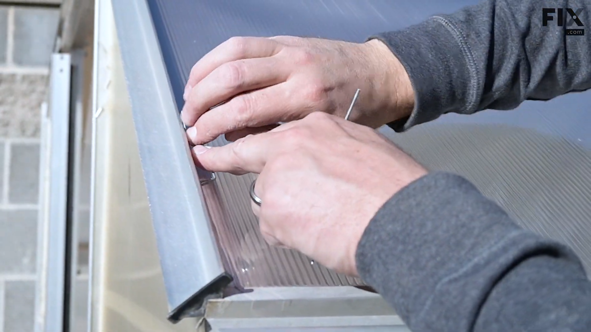 Expert technician securing a greenhouse roof panel by installing steel fixing clips around its sides