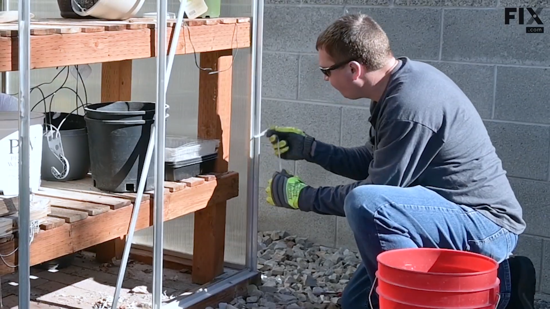 Expert technician peeling the leftover caulk off a greenhouse frame after removing all of its panels
