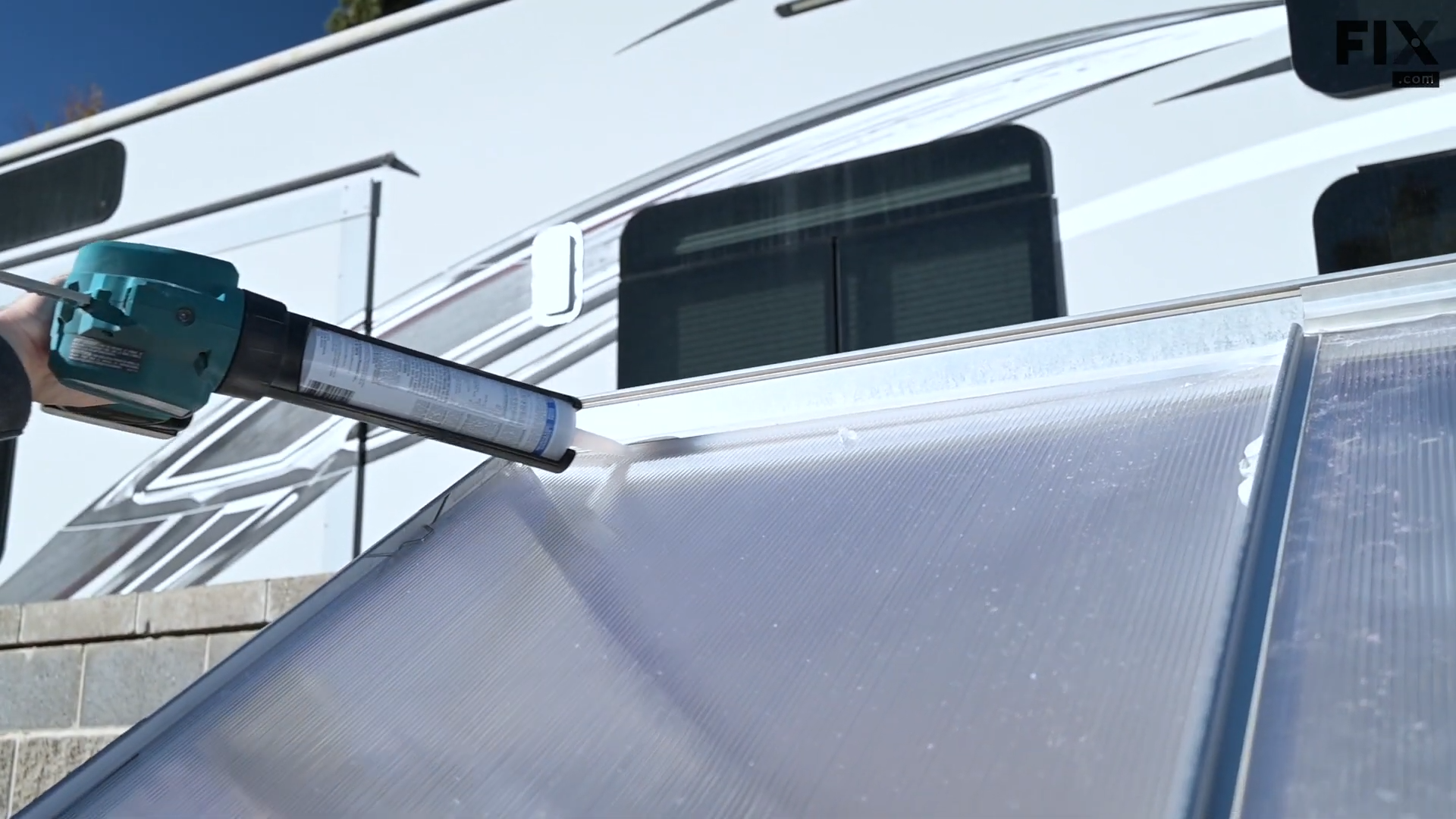 Expert technician sealing the sides of new panels on a greenhouse by putting caulk along their edges